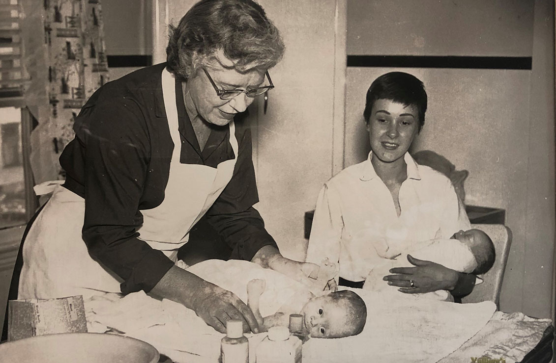 historic picture of two nurses providing care to newborns