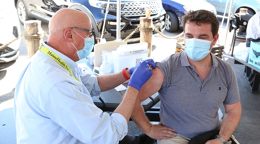Retired physician Nathaniel James, MD administers the J&J COVID-19 vaccine to Stepan Shonik, who is from Ukraine, at the MaineHealth walk-in vaccine clinic outside of Becky's Diner in Portland, ME (June 2, 2021).