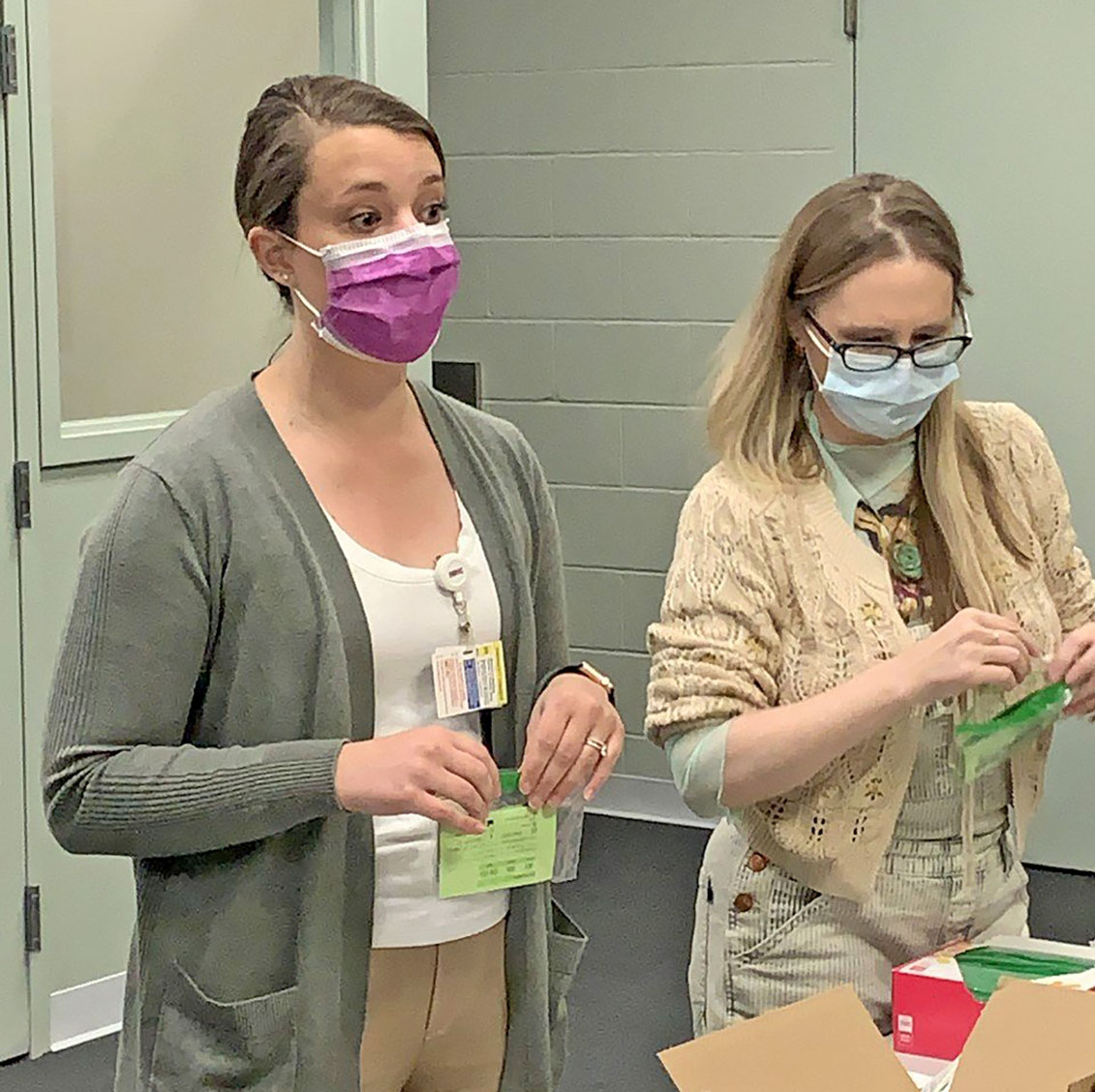 two women in masks packing harm reduction supplies